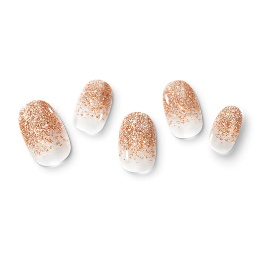 The gel nail wraps of ManiTini 'The Heart of Sparkling Rosé' showcasing the endless sparkling bubbles rising slowly in the pink rose wine.