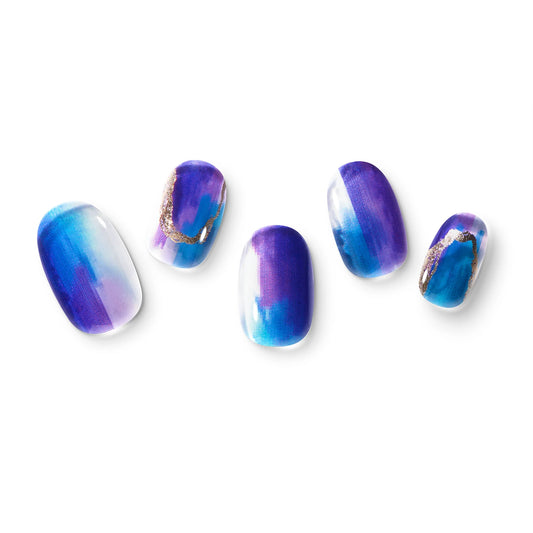 The gel nail wraps of ManiTini 'Miss me in December' showcasing the signature blues and purples, shining like a precious Tanzanite.